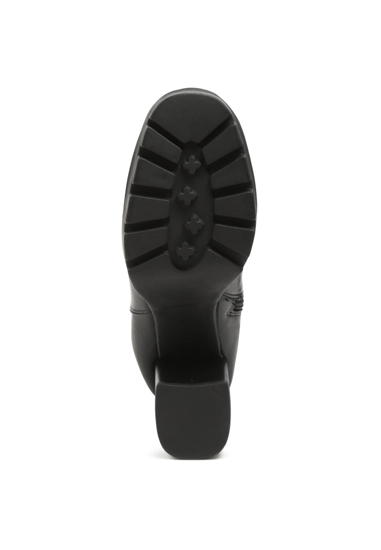 Stylish black ankle strap Chelsea boots with chunky diamante and side zipper, featuring block heels and rugged sole.