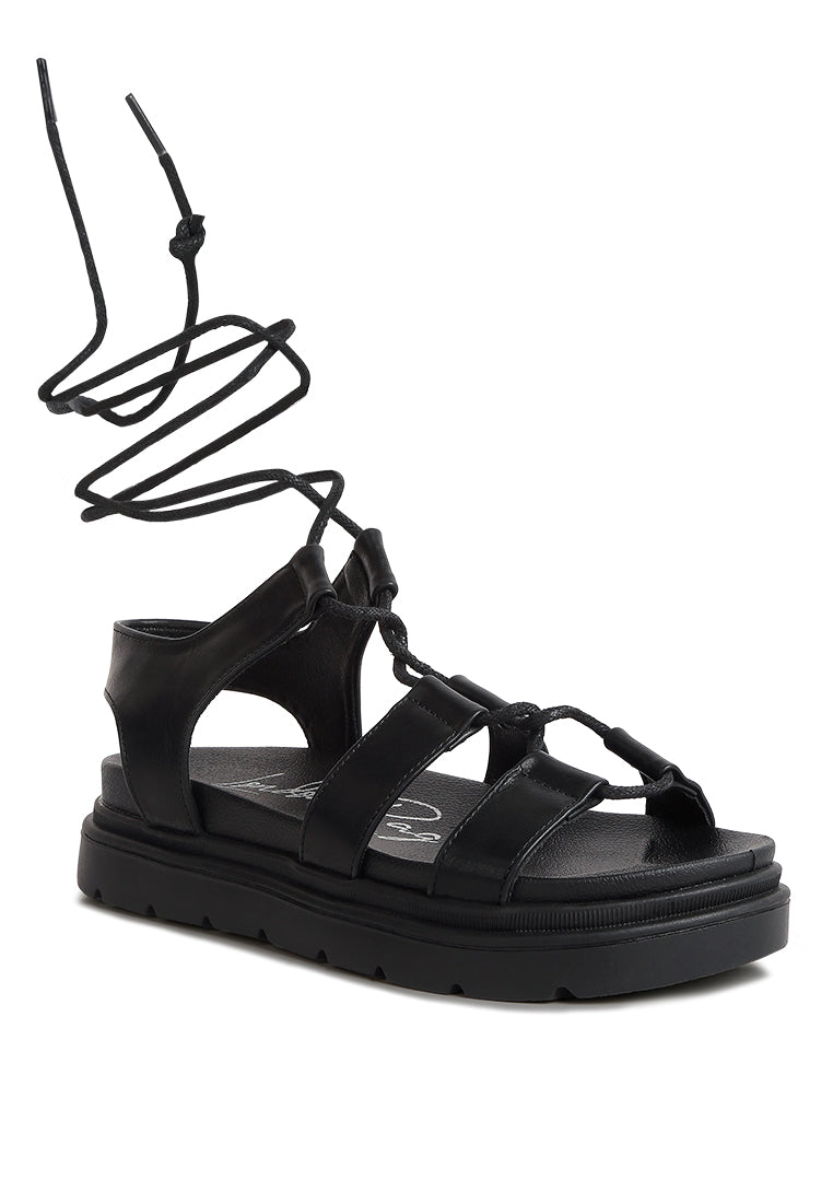 Dylan Strappy Gladiator Sandals featuring faux leather, lace-up detail, and open rounded toe design.
