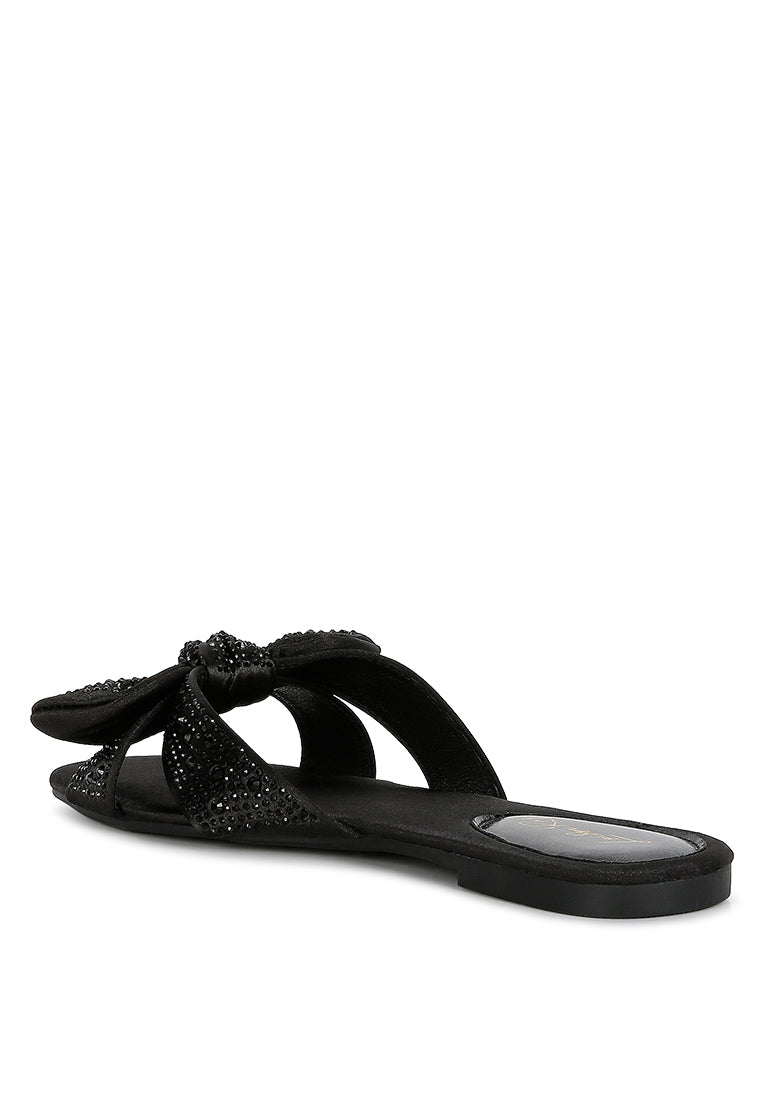 Fleurette Bow Flat Sandals featuring a satin upper, diamante bow, and flat heel design, perfect for elegant and comfortable wear.