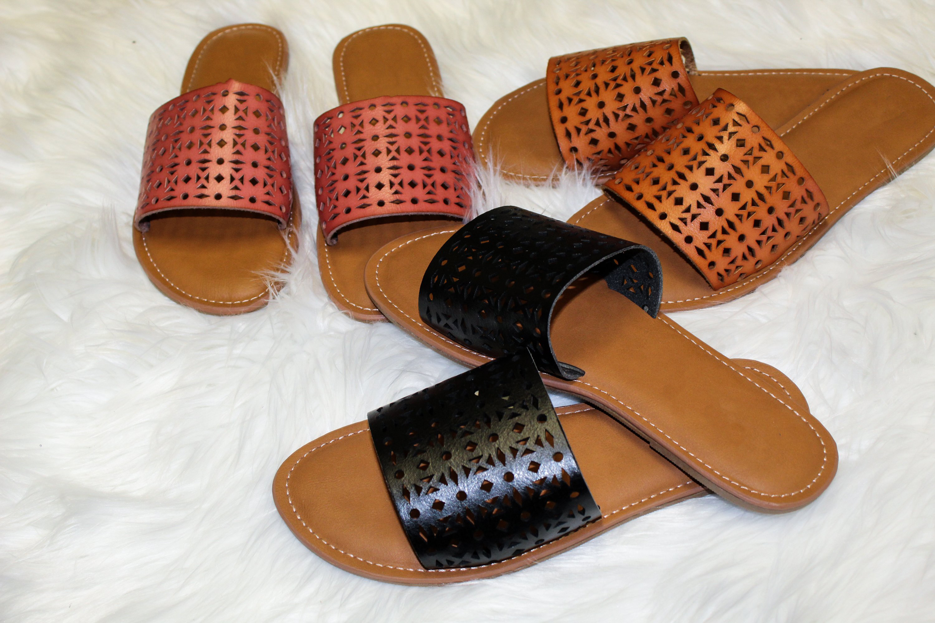 A pair of Women's Sandals Biarritz in black with a trendy perforated design and cushioned sole, perfect for summer outfits.