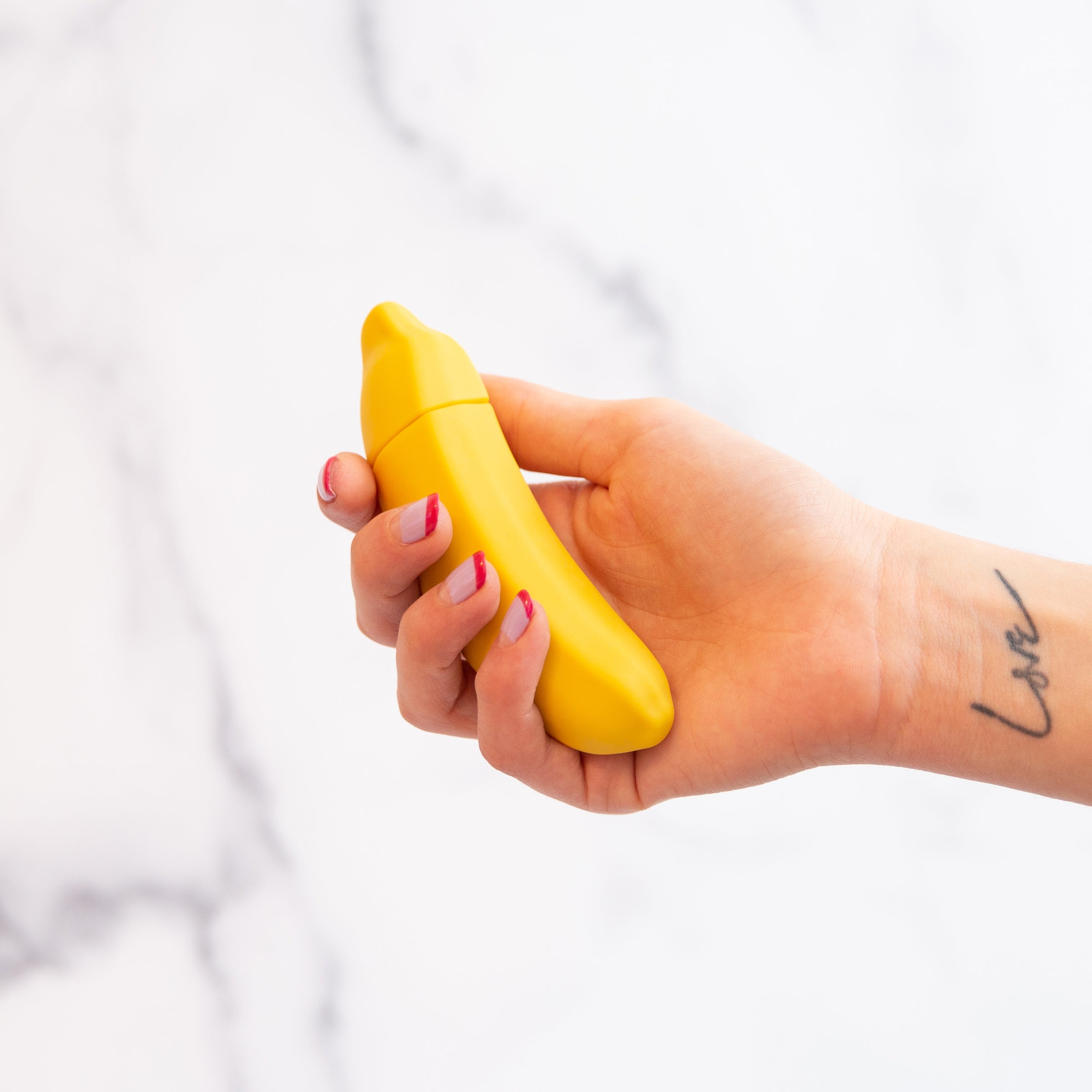 A vibrant yellow Banana Emojibator toy, shaped like a banana, showcasing its sleek design and waterproof features.