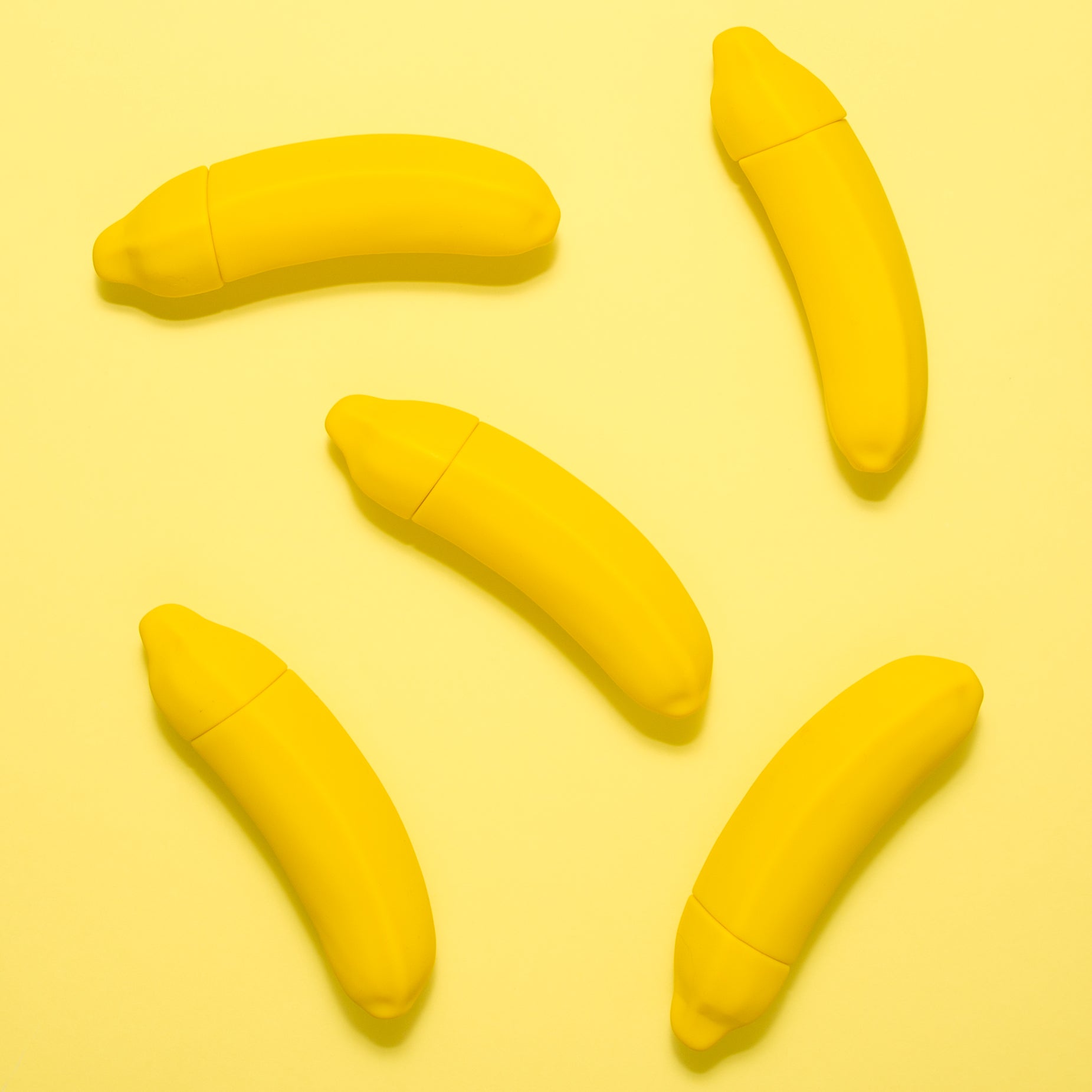 A vibrant yellow Banana Emojibator toy, shaped like a banana, showcasing its sleek design and waterproof features.