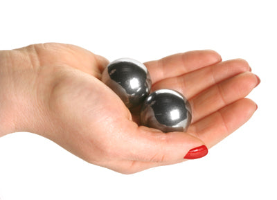 A pair of Carbon Steel XL Ben Wa Balls, 1.2 inches in diameter, displayed in a brocaded zippered pouch for discreet storage.