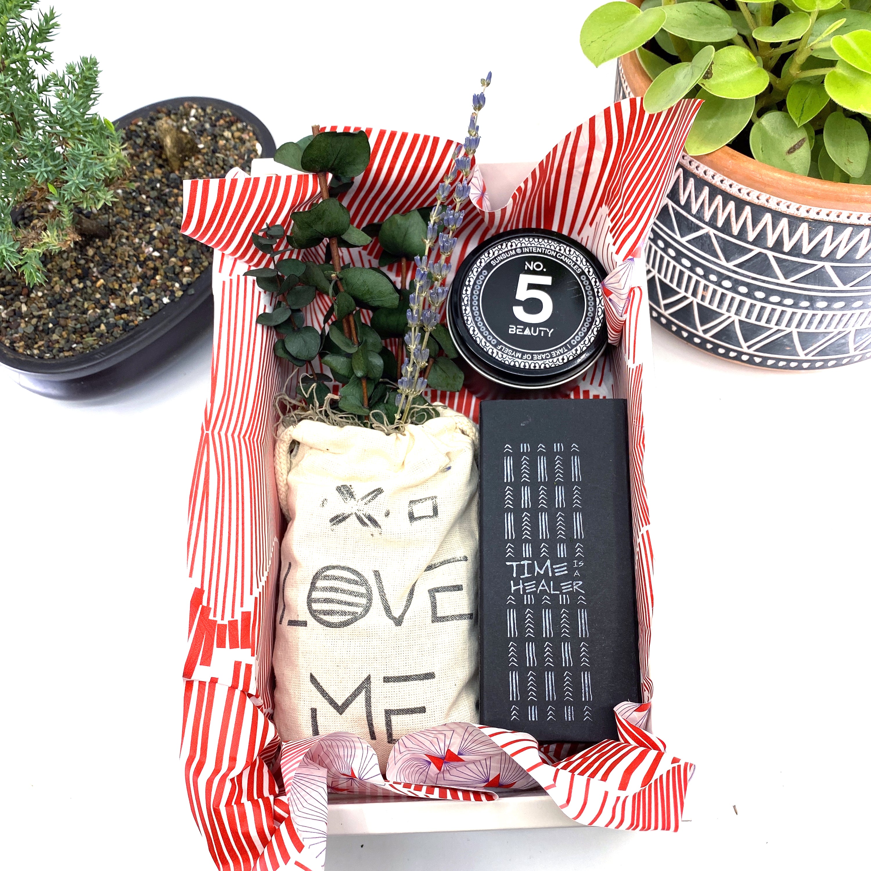 A beautifully arranged dried flower bouquet featuring lavender and eucalyptus, accompanied by a personal fragrance and intention candle, perfect for self-care.