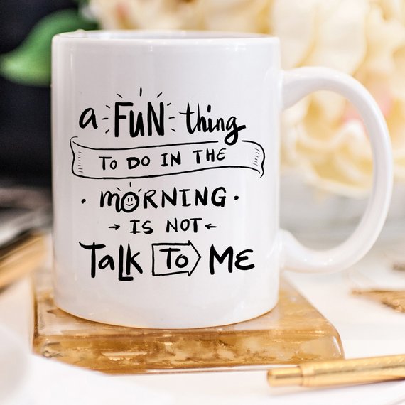 A humorous coffee mug with the phrase 'A Fun Thing To Do In The Morning Is NOT Talk To Me' printed on it, showcasing its unique design.
