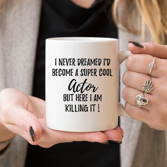 A stylish white ceramic mug featuring a vibrant design related to acting, perfect for gifts.