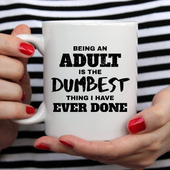 A humorous coffee mug with the phrase 'Being An Adult Is The Dumbest Thing I Have Ever Done' printed on it, showcasing a fun design.