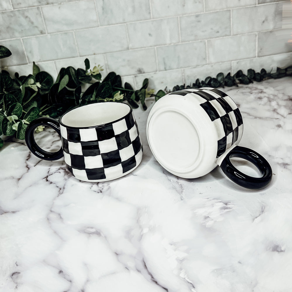 A stylish BW Checkered Mug featuring a hand-painted black and white checkered design, perfect for coffee, tea, or hot chocolate.