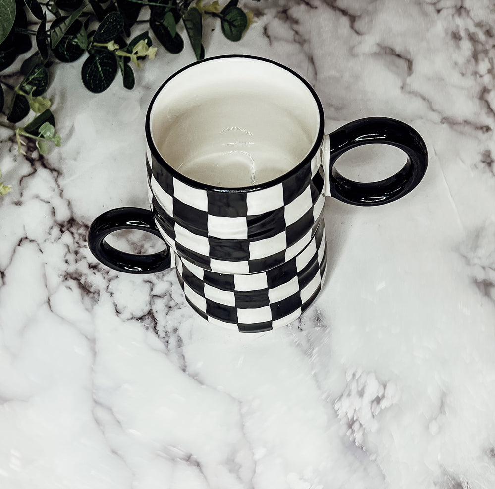 A stylish BW Checkered Mug featuring a hand-painted black and white checkered design, perfect for coffee, tea, or hot chocolate.
