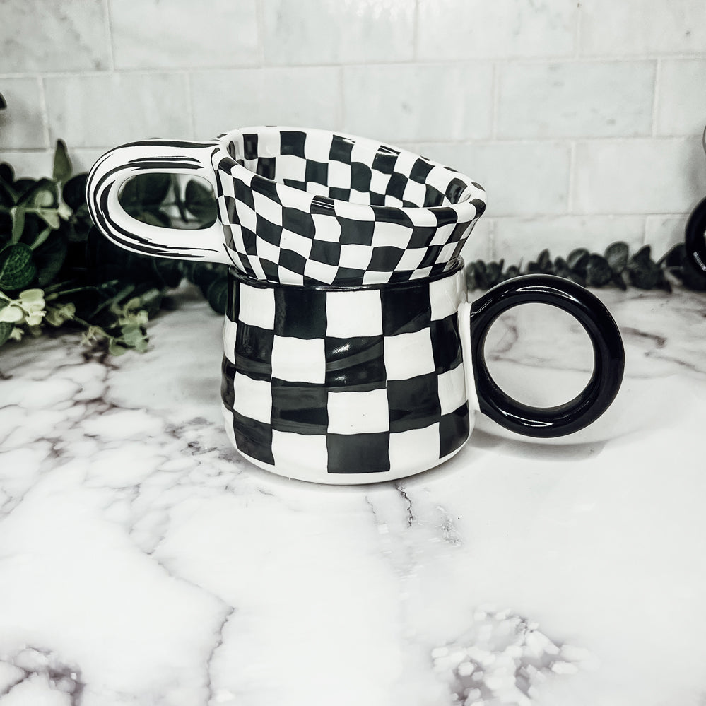 A stylish BW Checkered Mug featuring a hand-painted black and white checkered design, perfect for coffee, tea, or hot chocolate.