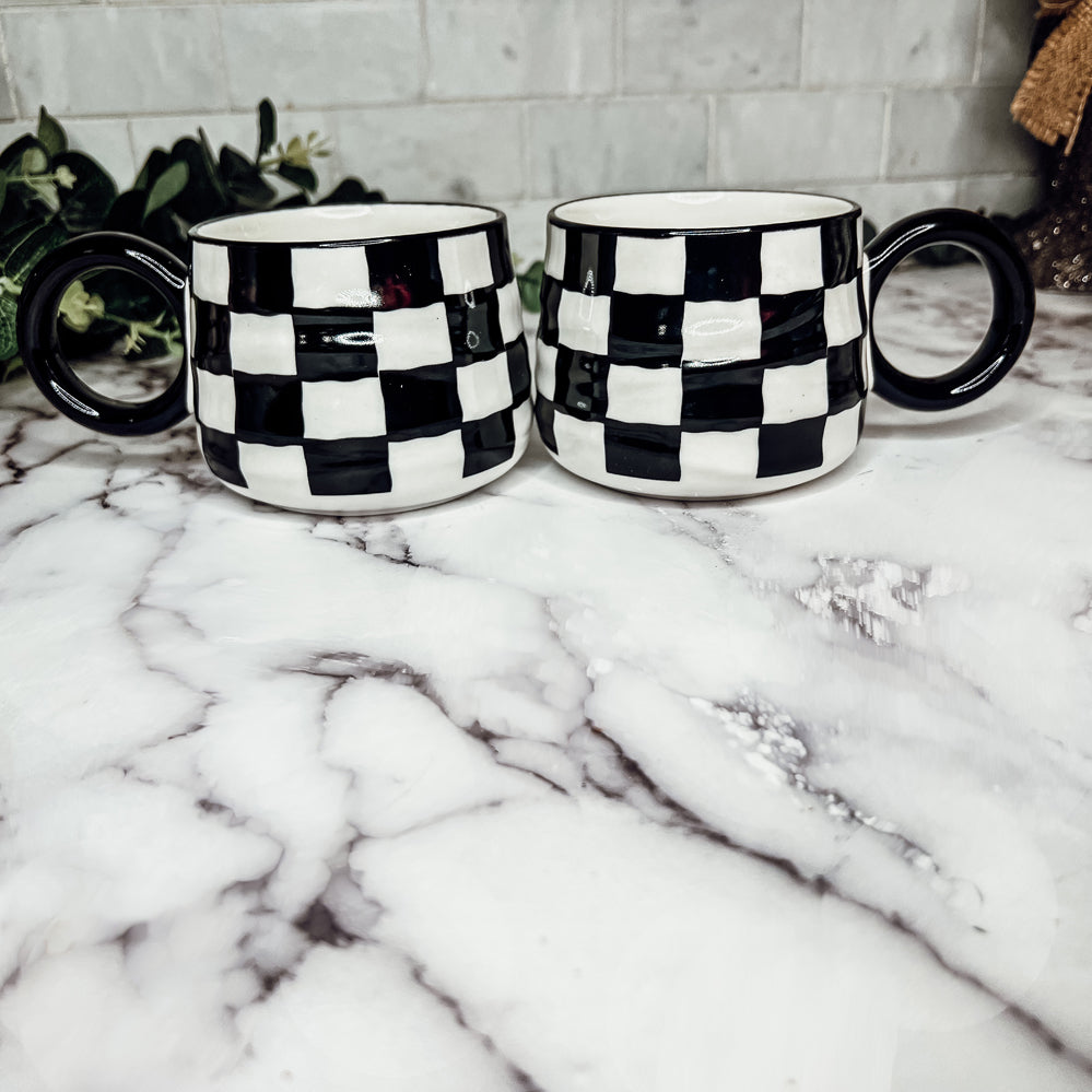 A stylish BW Checkered Mug featuring a hand-painted black and white checkered design, perfect for coffee, tea, or hot chocolate.