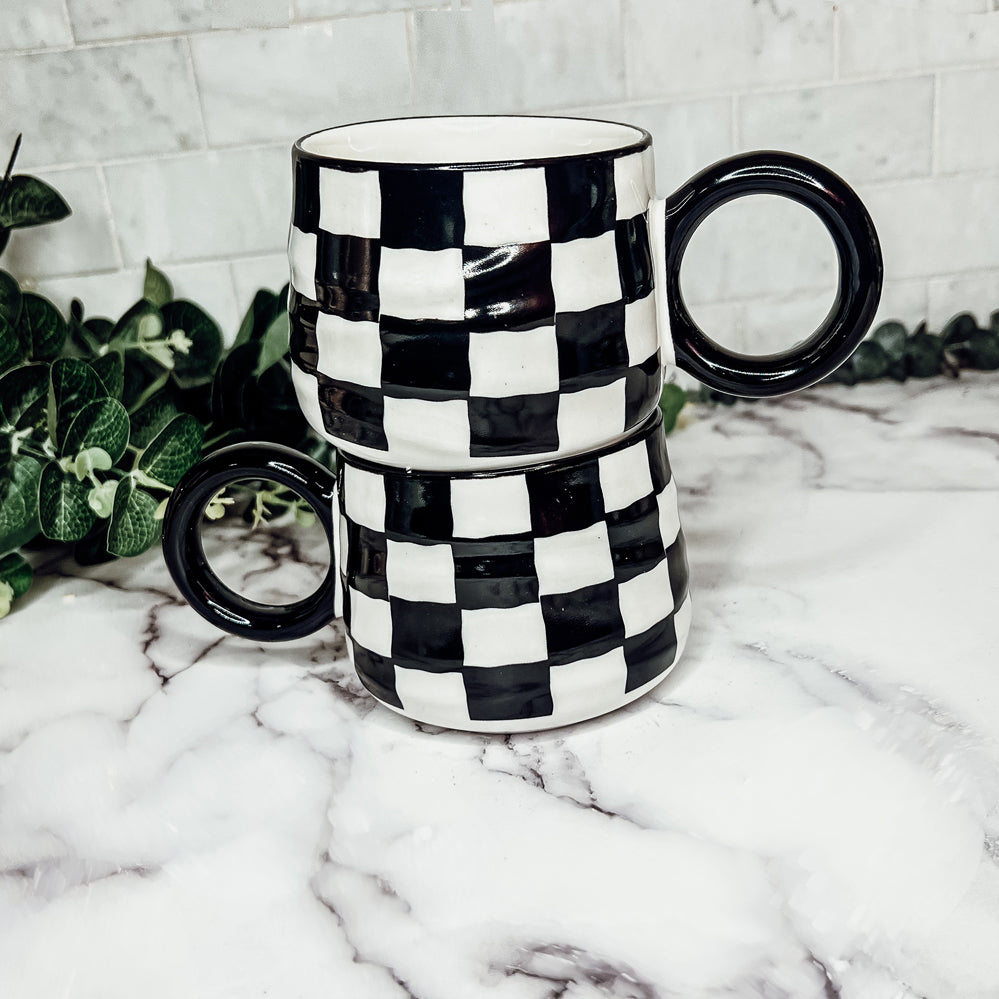 A stylish BW Checkered Mug featuring a hand-painted black and white checkered design, perfect for coffee, tea, or hot chocolate.