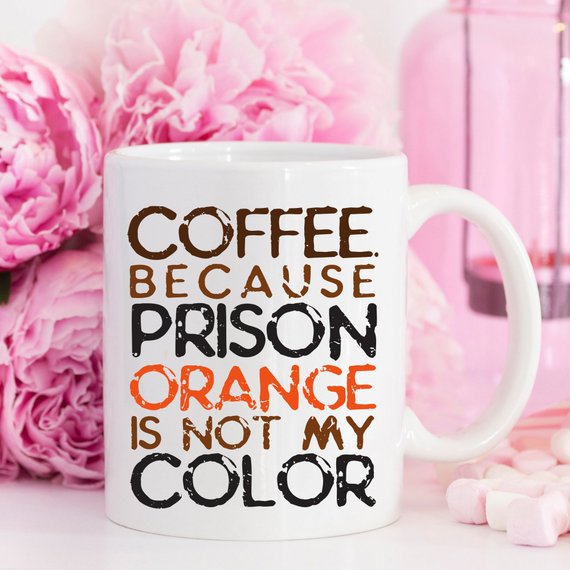 A humorous coffee mug with the phrase 'Because Prison Orange Is Not My Color' printed on it, showcasing a fun design suitable for coffee lovers.
