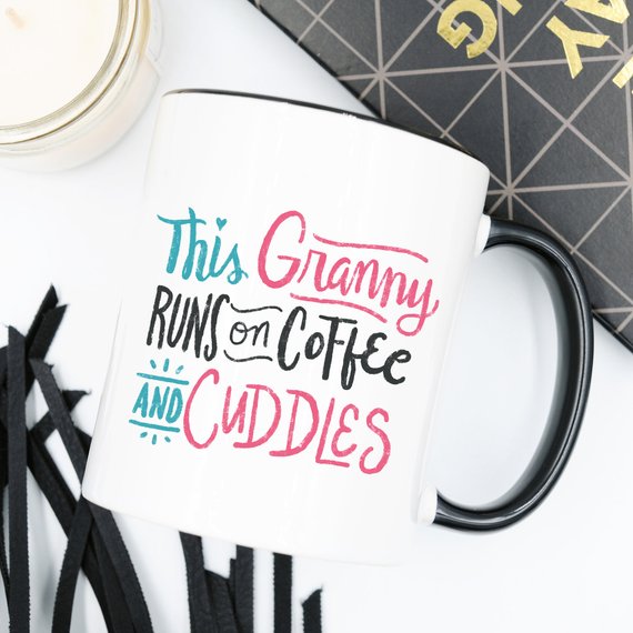 A humorous coffee mug featuring the phrase 'This Granny Runs On Coffee And Cuddles', crafted from high-grade ceramic.