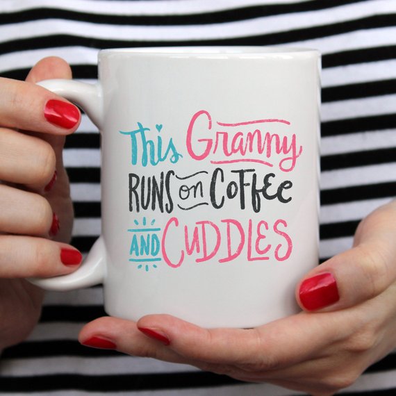 A humorous coffee mug featuring the phrase 'This Granny Runs On Coffee And Cuddles', crafted from high-grade ceramic.