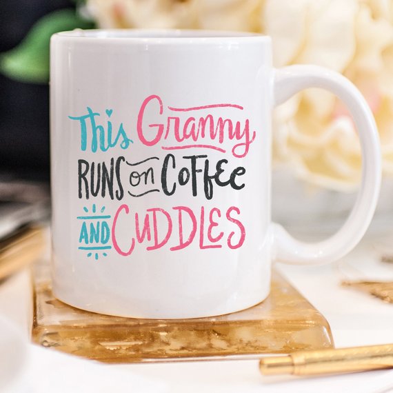 A humorous coffee mug featuring the phrase 'This Granny Runs On Coffee And Cuddles', crafted from high-grade ceramic.