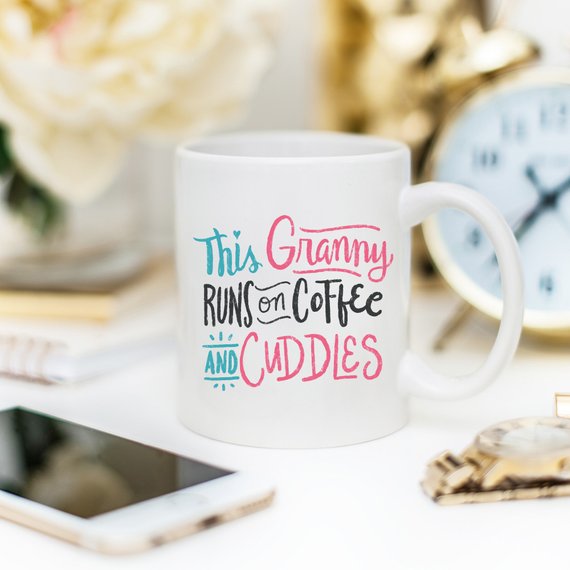 A humorous coffee mug featuring the phrase 'This Granny Runs On Coffee And Cuddles', crafted from high-grade ceramic.