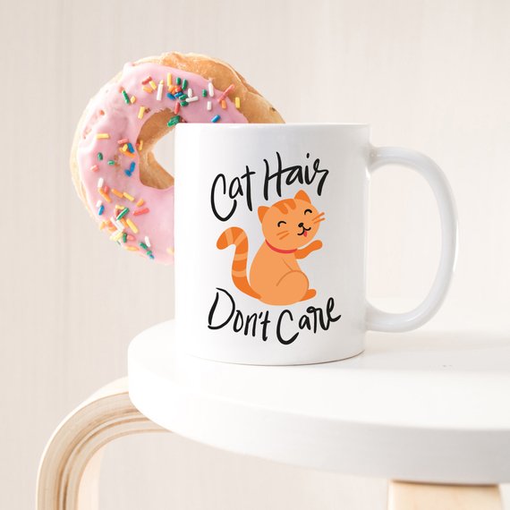 A humorous coffee mug featuring the phrase 'Cat Hair Don't Care', designed for cat lovers, made from high-quality ceramic with a glossy finish.