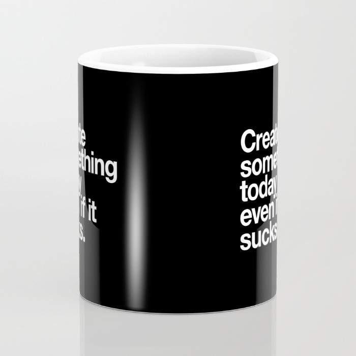 A 15-ounce ceramic coffee mug featuring the phrase 'Create Something Today Even If It Sucks' with a wrap-around art design and a large handle.