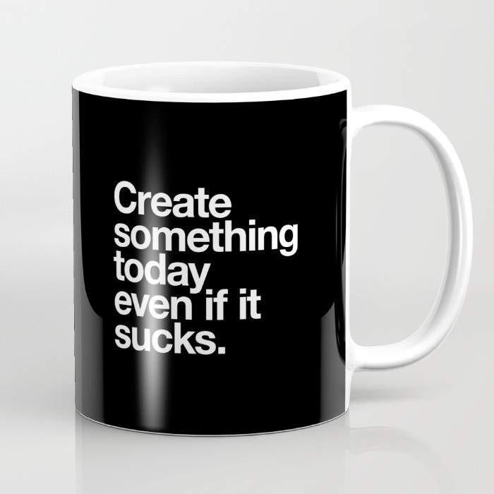 A 15-ounce ceramic coffee mug featuring the phrase 'Create Something Today Even If It Sucks' with a wrap-around art design and a large handle.