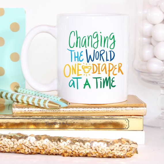 Funny coffee mug with the phrase 'Changing The World, One Diaper At A Time' designed for new dads, made of high-quality ceramic.