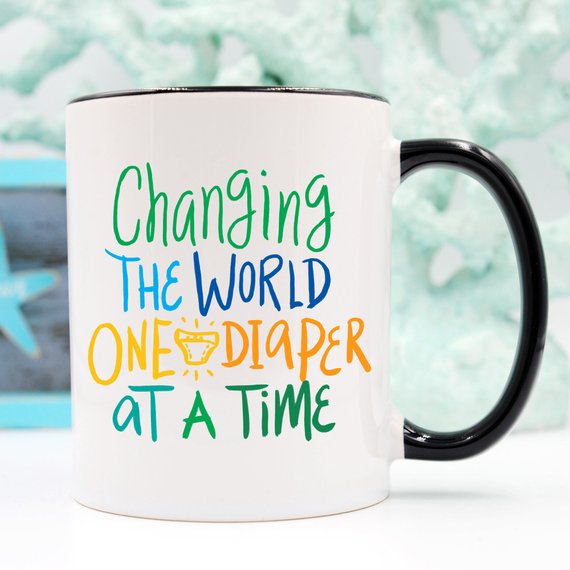Funny coffee mug with the phrase 'Changing The World, One Diaper At A Time' designed for new dads, made of high-quality ceramic.