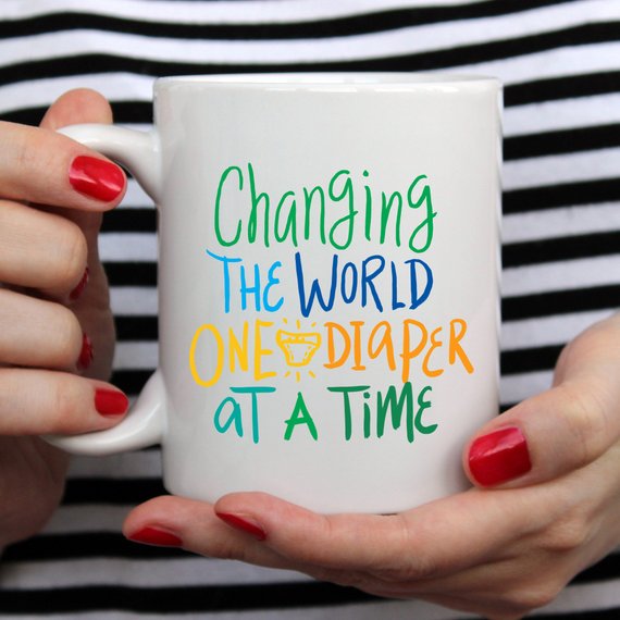 Funny coffee mug with the phrase 'Changing The World, One Diaper At A Time' designed for new dads, made of high-quality ceramic.