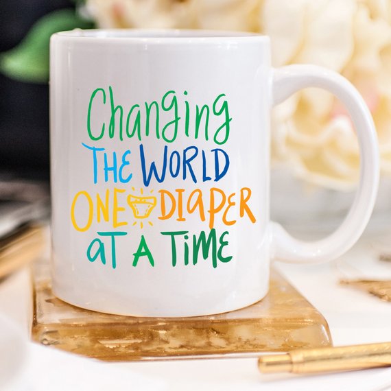 Funny coffee mug with the phrase 'Changing The World, One Diaper At A Time' designed for new dads, made of high-quality ceramic.