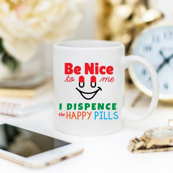 Funny Nurse Mug featuring the phrase 'Be Nice To Me, I Dispence The Happy Pills', designed for nurses with a humorous touch.