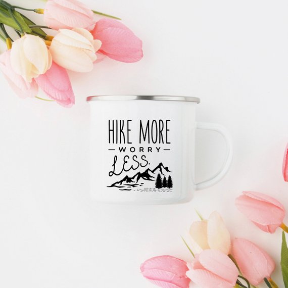 A white enamel mug with a stainless steel rim, featuring a vibrant wanderlust design printed on both sides, perfect for hiking and outdoor adventures.