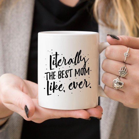 A white ceramic coffee mug with the text 'Literally The Best Mom Like Ever' printed in a fun, colorful font, perfect for Mother's Day gifts.
