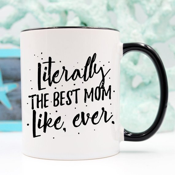 A white ceramic coffee mug with the text 'Literally The Best Mom Like Ever' printed in a fun, colorful font, perfect for Mother's Day gifts.