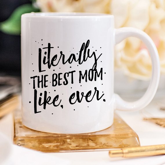 A white ceramic coffee mug with the text 'Literally The Best Mom Like Ever' printed in a fun, colorful font, perfect for Mother's Day gifts.