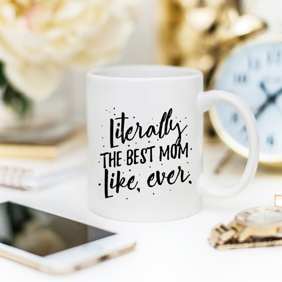 A white ceramic coffee mug with the text 'Literally The Best Mom Like Ever' printed in a fun, colorful font, perfect for Mother's Day gifts.