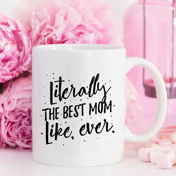 A white ceramic coffee mug with the text 'Literally The Best Mom Like Ever' printed in a fun, colorful font, perfect for Mother's Day gifts.