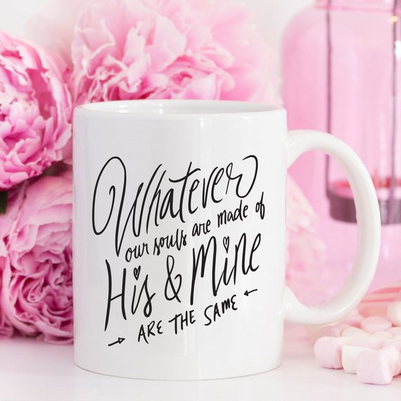 A white ceramic mug featuring a design inspired by Emily Bronte's Withering Heights, showcasing vibrant colors and a black handle.