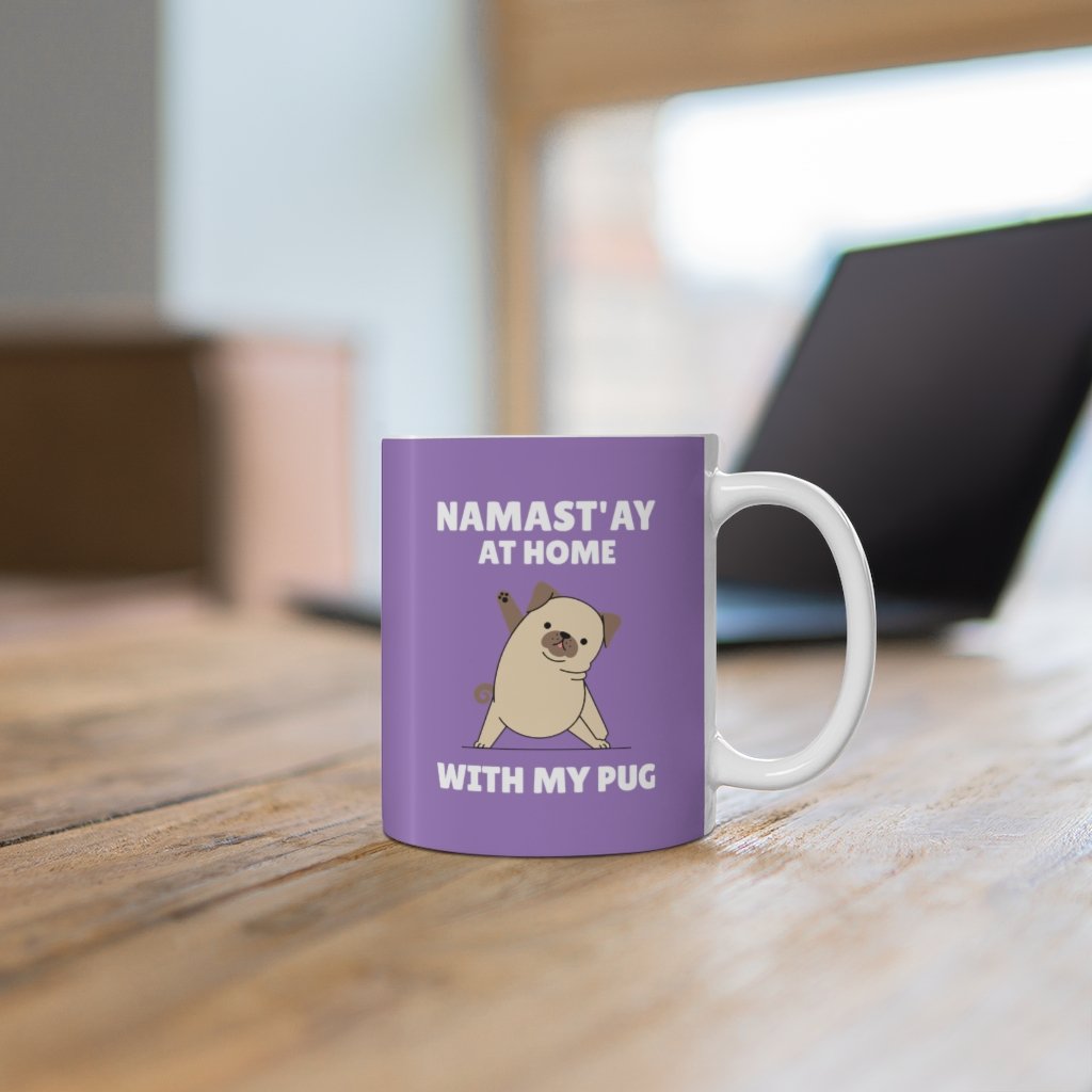 A white ceramic mug with the phrase 'Namast'ay Home with My Pug' and a cute pug illustration, perfect for coffee or tea.