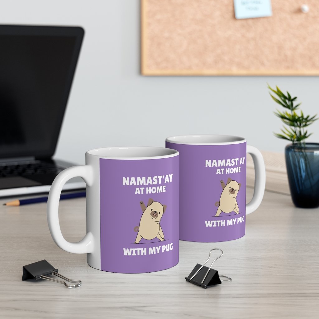 A white ceramic mug with the phrase 'Namast'ay Home with My Pug' and a cute pug illustration, perfect for coffee or tea.