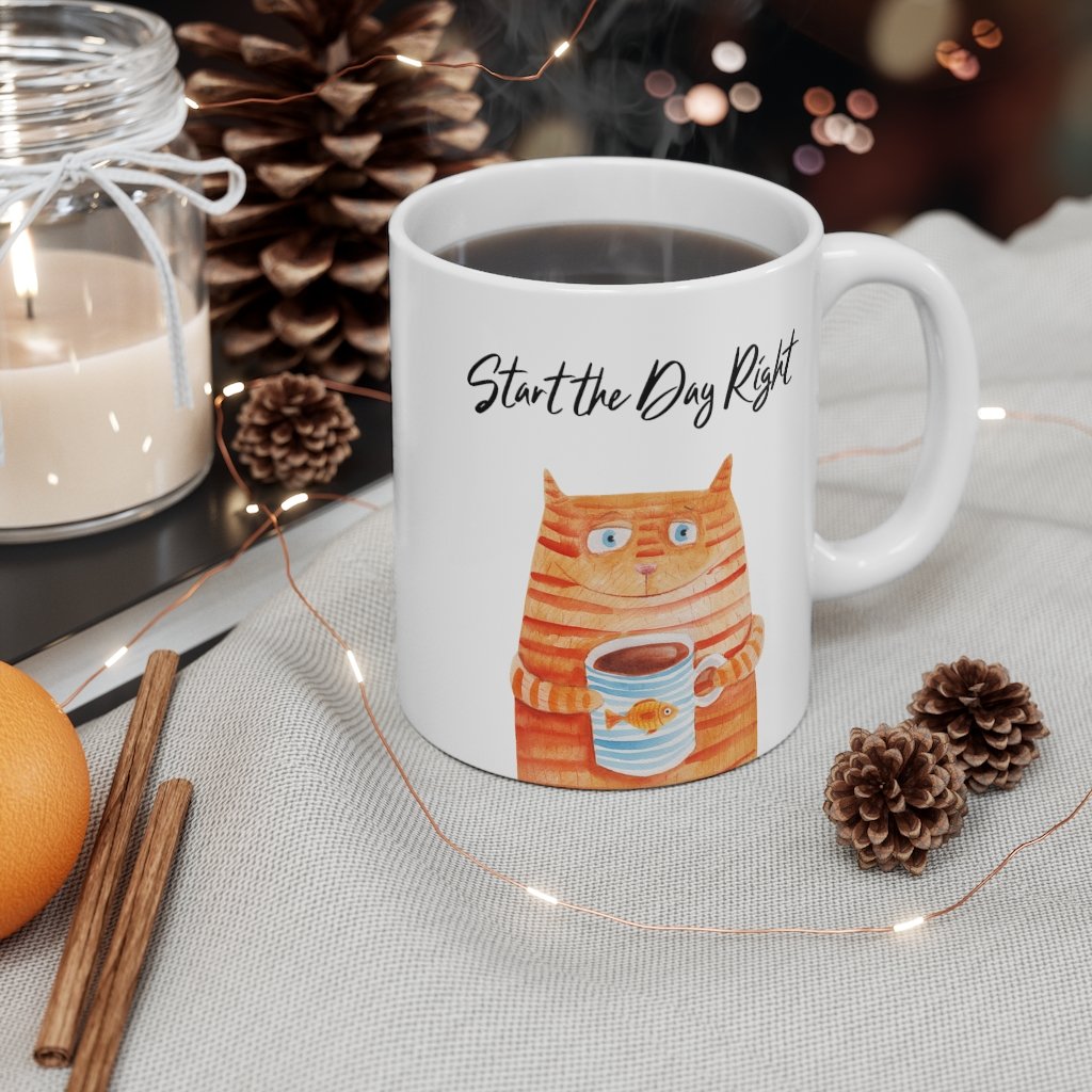 A white ceramic coffee mug featuring a cute cat holding a goldfish, perfect for coffee, tea, or hot chocolate.