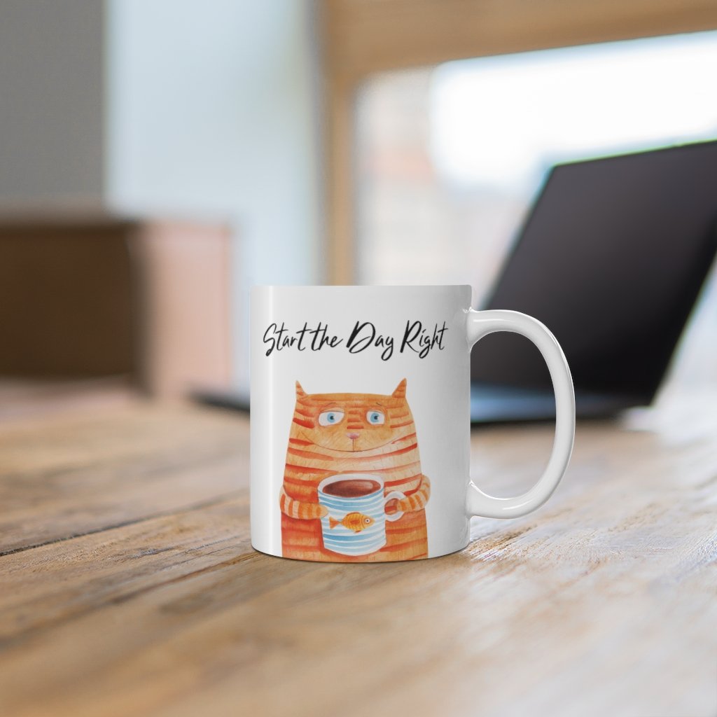 A white ceramic coffee mug featuring a cute cat holding a goldfish, perfect for coffee, tea, or hot chocolate.