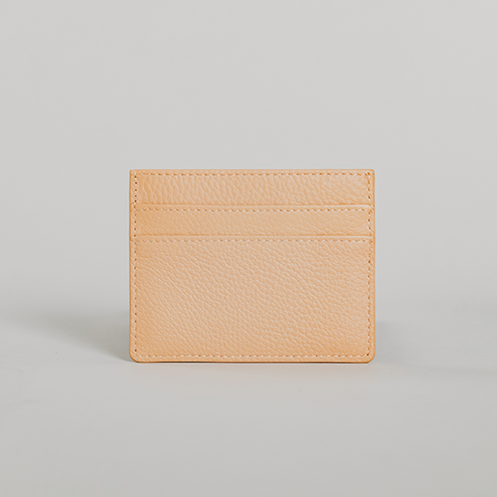 Sandy Nude Pebble Card Holder made of leather with suede detailing, featuring five card slots and personalization options.