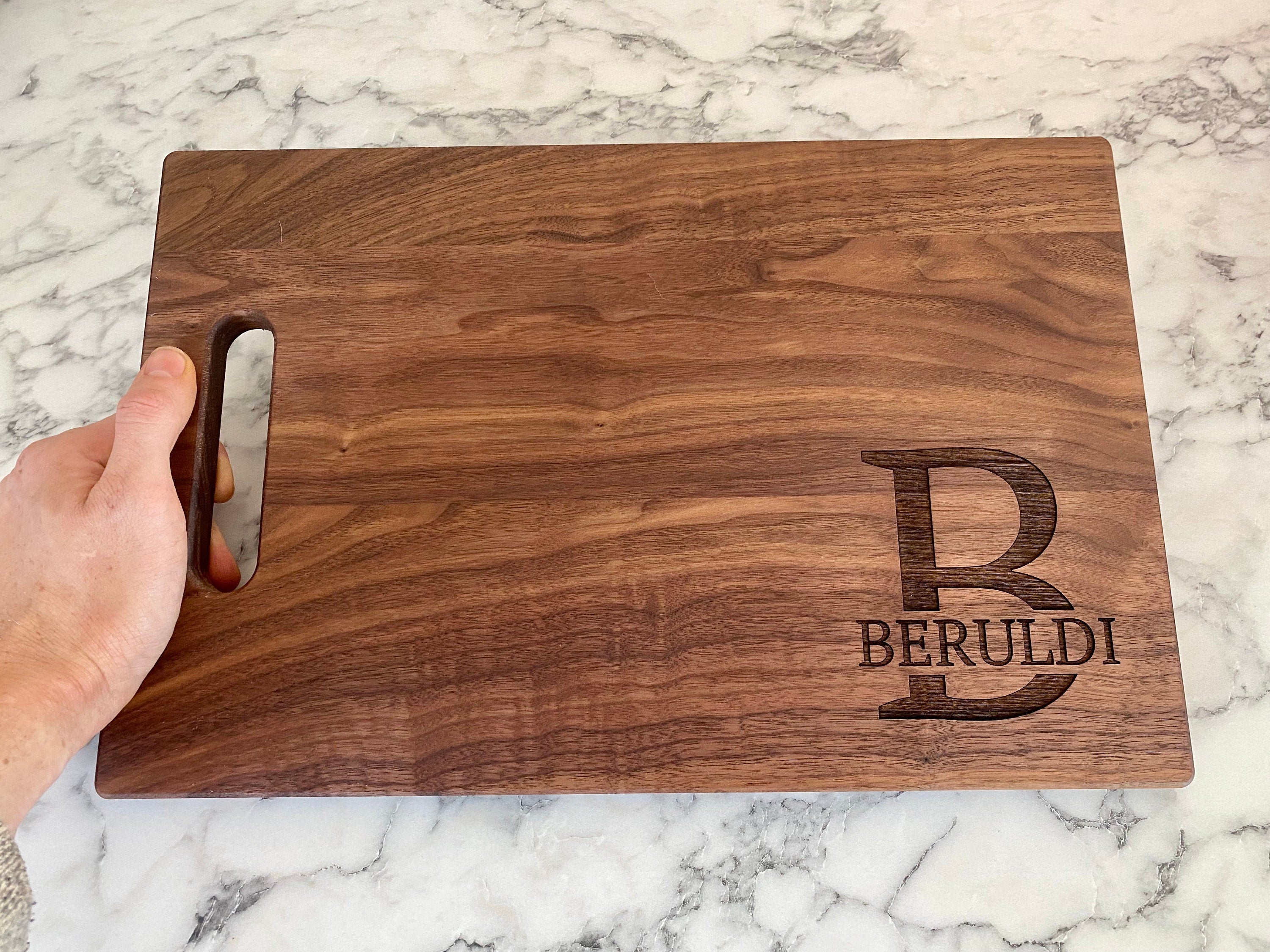 A beautifully crafted 10.5x16 inch walnut wood cutting board with custom engraving options, showcasing its elegant design and functionality.