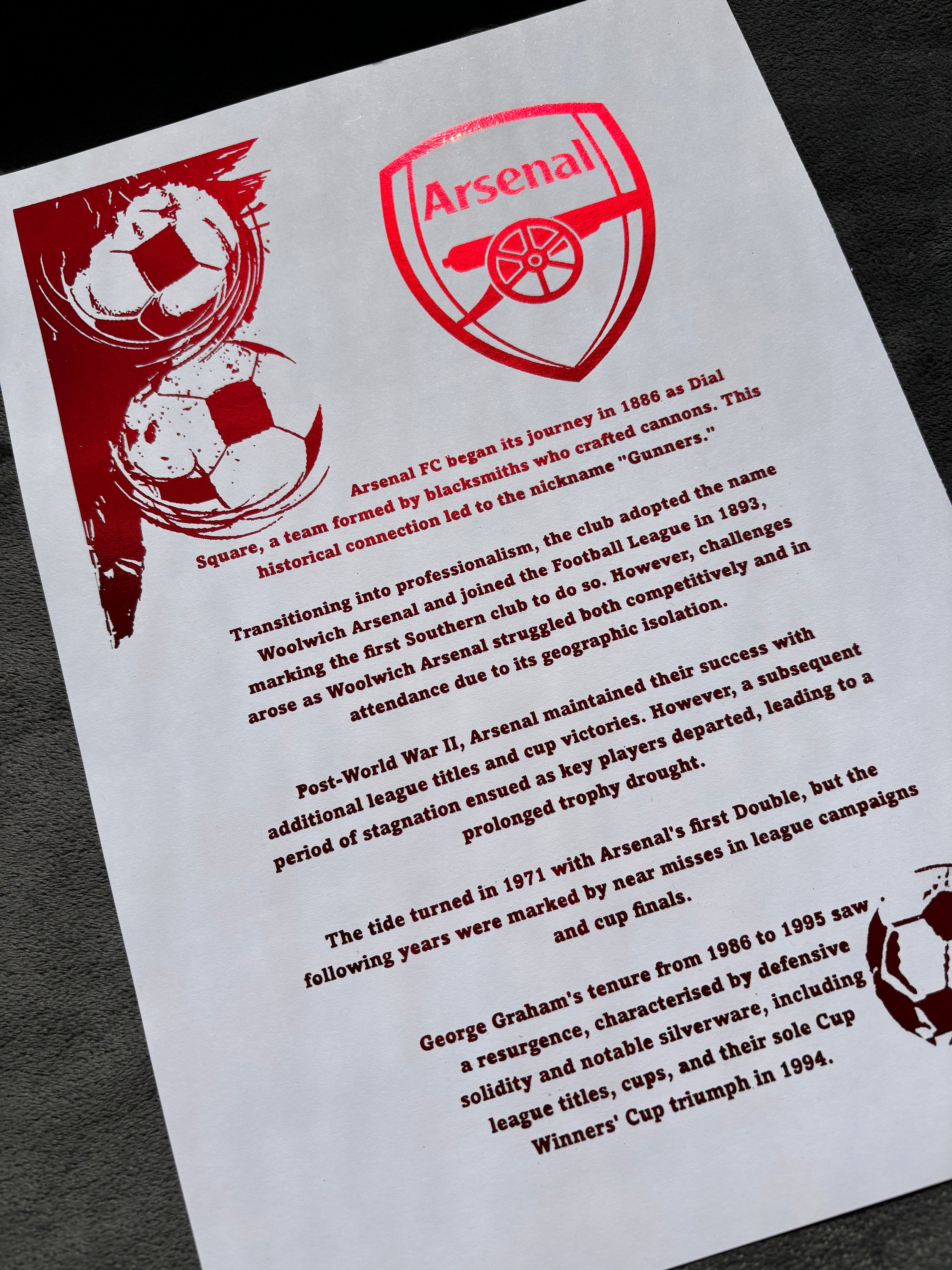 A4 foil print featuring the Arsenal FC logo with red foil accents, showcasing club history and achievements.