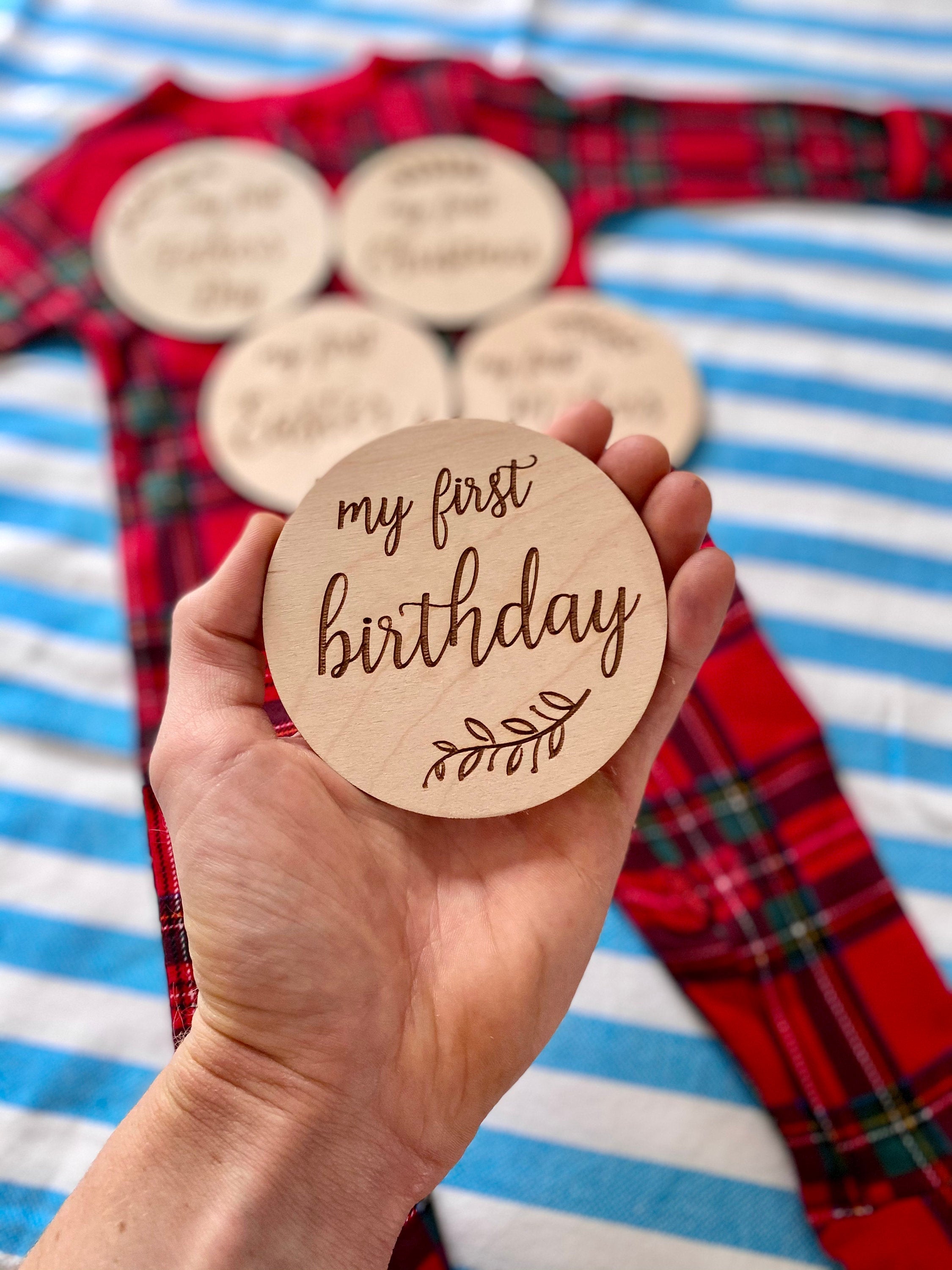 A set of beautifully crafted Birch wood milestone discs for baby's first holidays, featuring engraved text and a Kraft storage box.