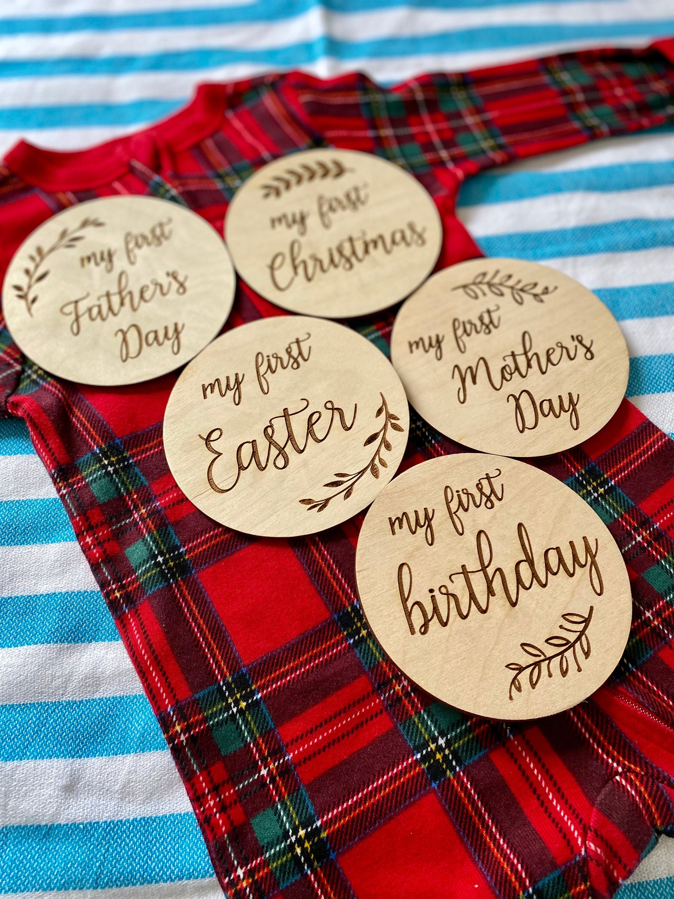 A set of beautifully crafted Birch wood milestone discs for baby's first holidays, featuring engraved text and a Kraft storage box.