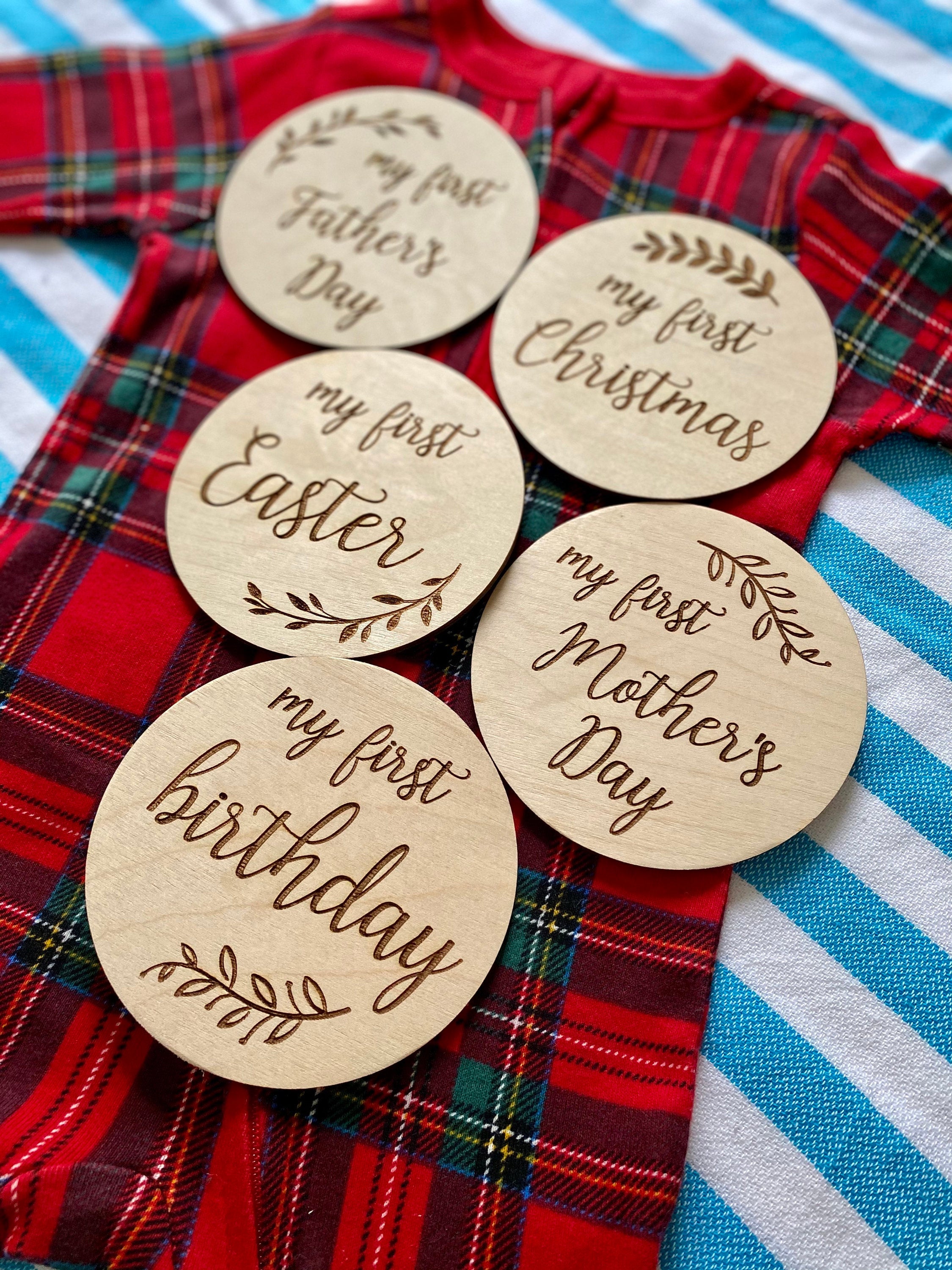 A set of beautifully crafted Birch wood milestone discs for baby's first holidays, featuring engraved text and a Kraft storage box.
