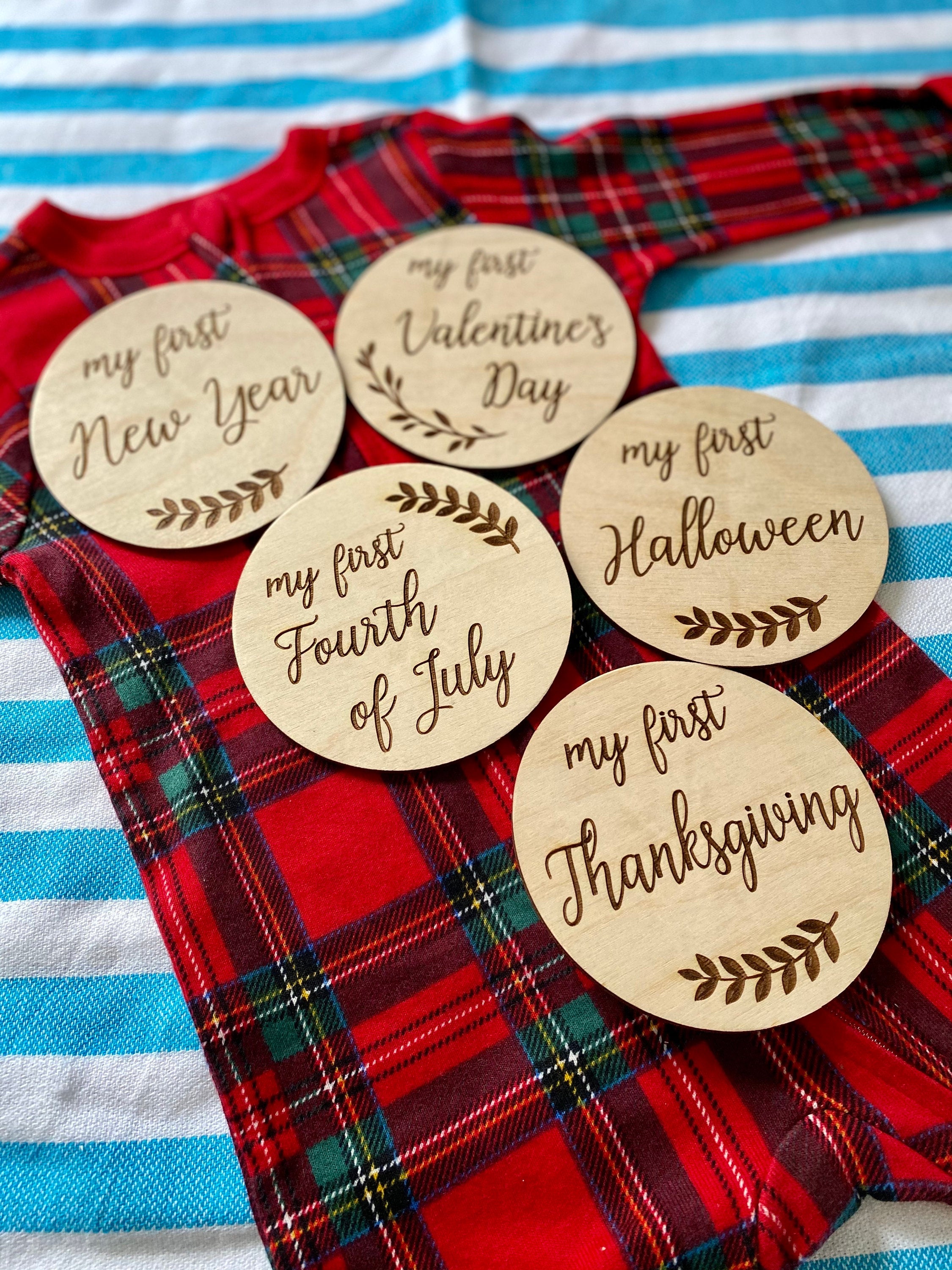 A set of beautifully crafted Birch wood milestone discs for baby's first holidays, featuring engraved text and a Kraft storage box.