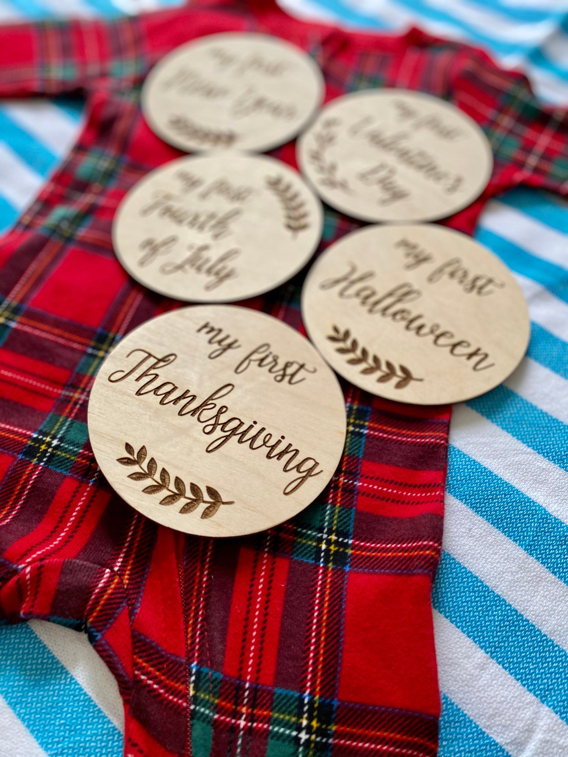 A set of beautifully crafted Birch wood milestone discs for baby's first holidays, featuring engraved text and a Kraft storage box.