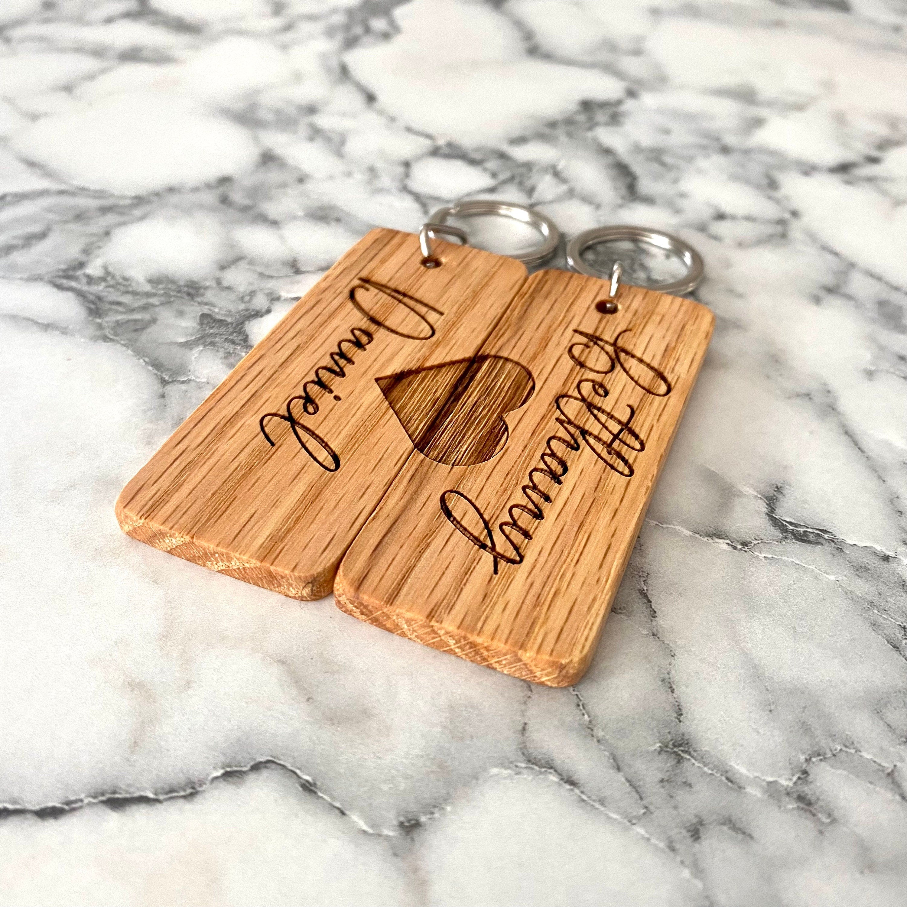 Couples Engraved Wood Keychain set featuring personalized names and a joined heart design, crafted from solid hardwood oak.
