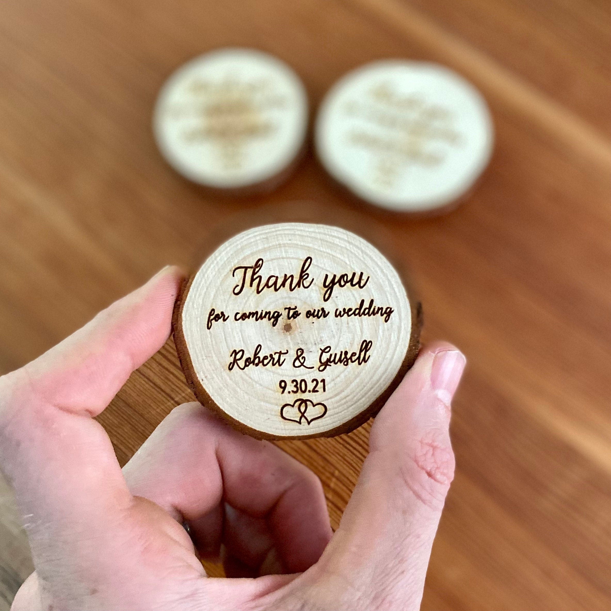 Custom engraved wood slice wedding favor with magnet, featuring personalized names and date.
